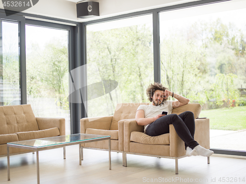 Image of young man using a mobile phone  at home