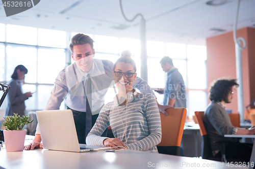 Image of Two Business People Working With laptop in office