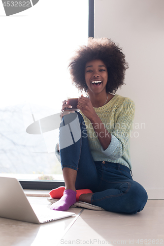 Image of black woman in the living room on the floor