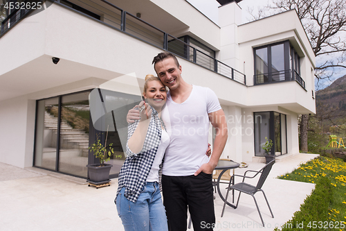 Image of couple hugging in front of  new luxury home