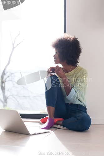 Image of black woman in the living room on the floor