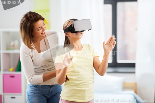 Image of mother and daughter in vr glasses playing at home