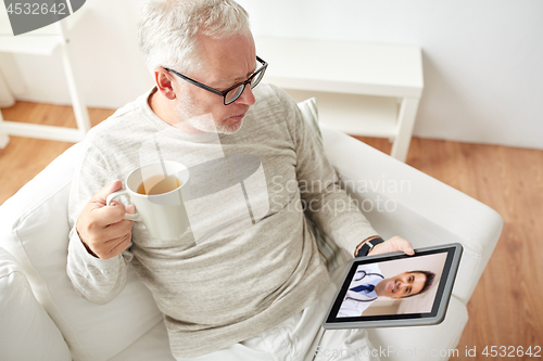 Image of senior man having video call with doctor on tablet