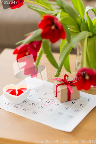 Image of gift box, calendar sheet and flowers on table