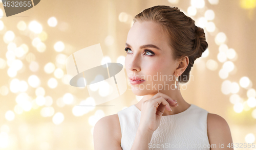 Image of woman in white dress with diamond earring