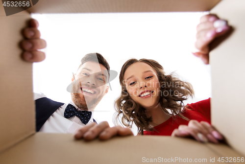 Image of happy couple opening christmas gift box