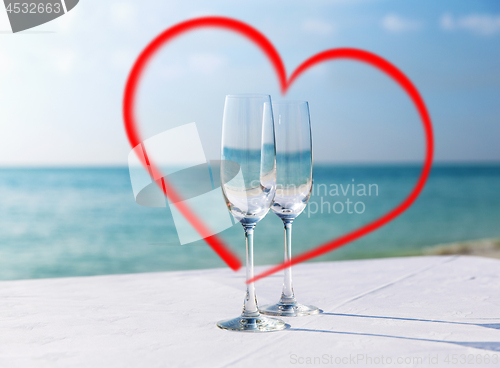 Image of two champagne glasses framed by red heart shape