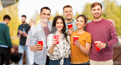 Image of group of friends toasting drinks at rooftop party