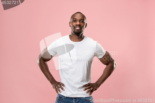 Image of The happy business man standing and smiling against pink background.