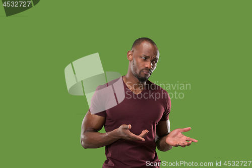 Image of Beautiful male half-length portrait isolated on green studio backgroud. The young emotional surprised man