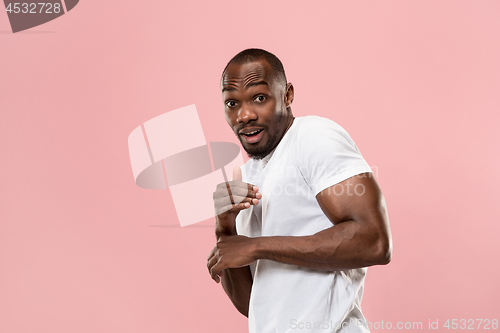 Image of Beautiful male half-length portrait isolated on pink studio backgroud. The young emotional surprised man