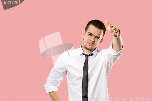 Image of Beautiful male half-length portrait isolated on pink studio backgroud. The young emotional surprised man