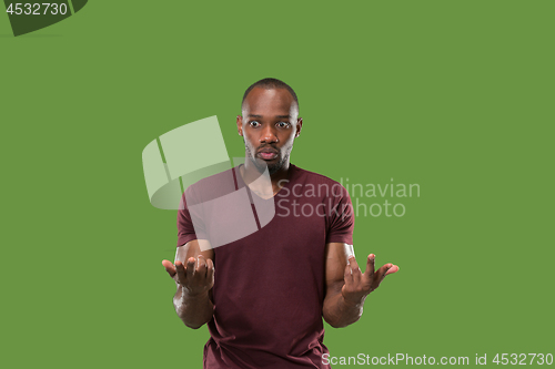 Image of Beautiful male half-length portrait isolated on green studio backgroud. The young emotional surprised man