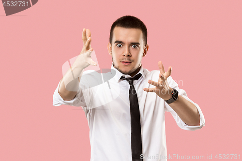 Image of Beautiful male half-length portrait isolated on pink studio backgroud. The young emotional surprised man