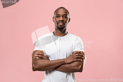 Image of The happy business man standing and smiling against pink background.