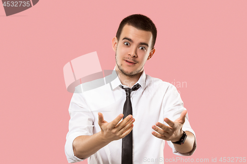 Image of Beautiful male half-length portrait isolated on pink studio backgroud. The young emotional surprised man