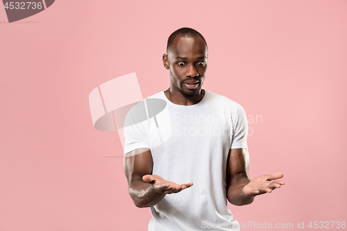 Image of Beautiful male half-length portrait isolated on pink studio backgroud. The young emotional surprised man