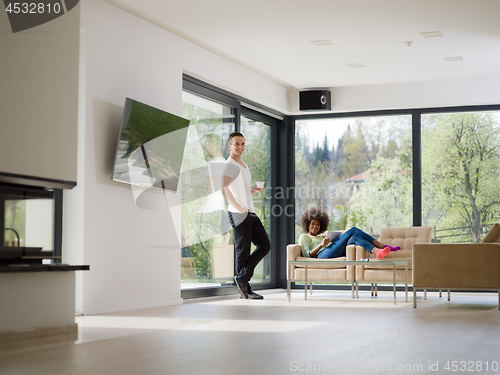 Image of multiethnic couple relaxing at  home with tablet computers