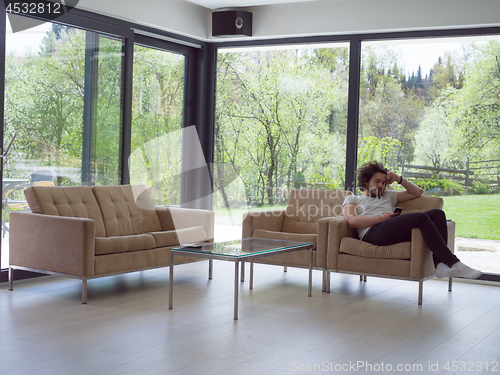 Image of young man using a mobile phone  at home