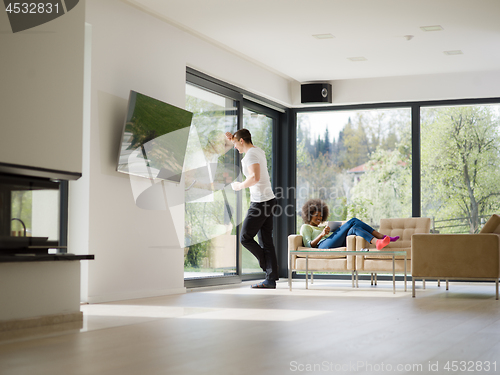 Image of multiethnic couple relaxing at  home with tablet computers