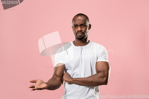 Image of Beautiful male half-length portrait isolated on pink studio backgroud. The young emotional surprised man