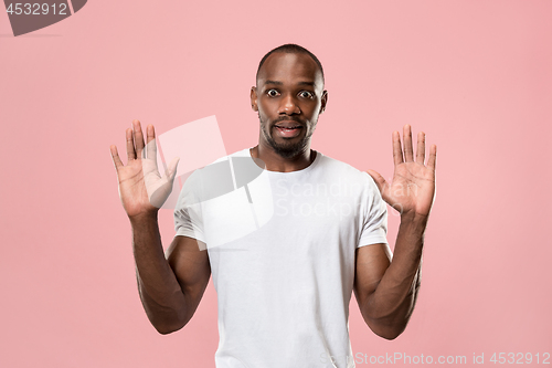 Image of Beautiful male half-length portrait isolated on pink studio backgroud. The young emotional surprised man