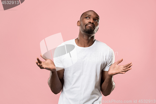 Image of Beautiful male half-length portrait isolated on pink studio backgroud. The young emotional surprised man