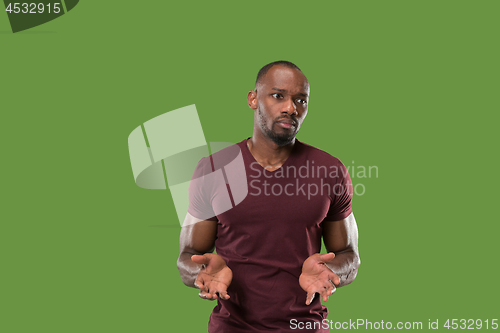 Image of Beautiful male half-length portrait isolated on green studio backgroud. The young emotional surprised man