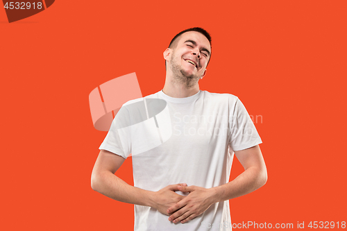 Image of The happy businessman standing and smiling against orange background.