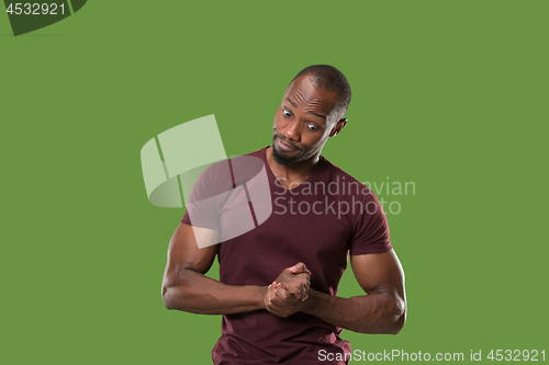 Image of Let me think. Doubtful pensive man with thoughtful expression making choice against green background