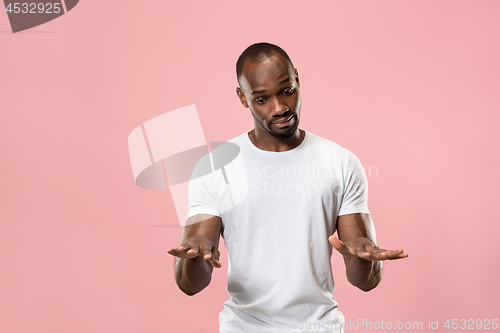 Image of Beautiful male half-length portrait isolated on pink studio backgroud. The young emotional surprised man