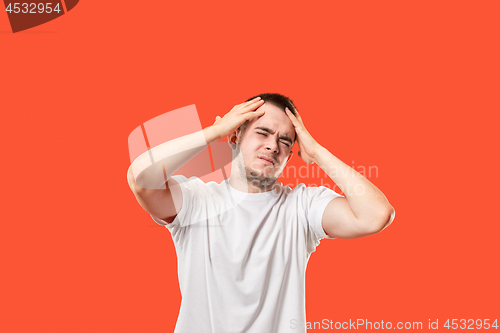 Image of Man having headache. Isolated over red background.