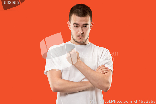 Image of The young emotional angry man screaming on orange studio background