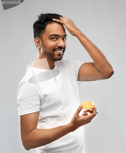 Image of indian man applying hair wax or styling gel