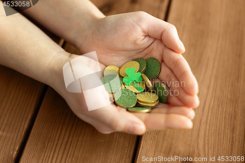 Image of hands with golden coins and shamrock leaf