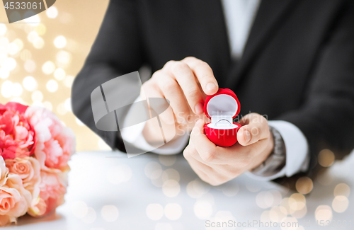 Image of man with diamond engagement ring in red gift box