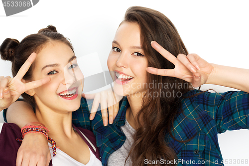 Image of happy teenage girls hugging and showing peace sign