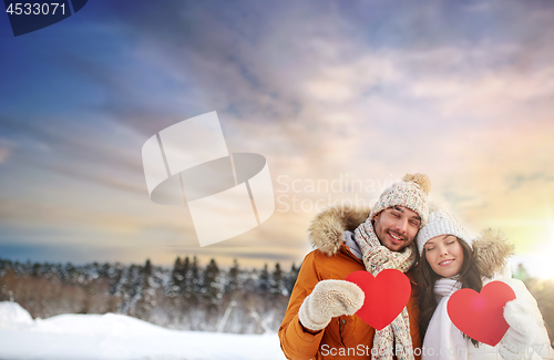 Image of happy couple with red hearts over winter nature