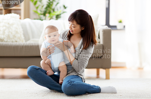 Image of happy young mother with little baby at home
