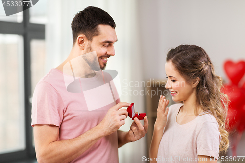 Image of man giving woman engagement ring on valentines day