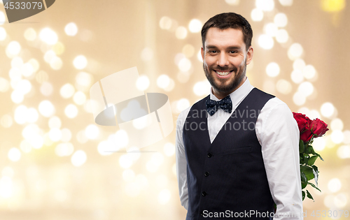 Image of happy man with red roses behind his back