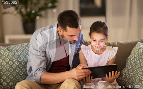 Image of father and daughter with tablet computer at home