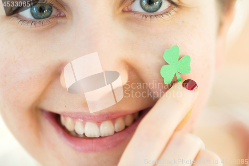 Image of close up of happy young woman face with shamrock