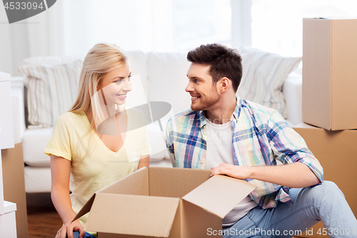 Image of happy couple unpacking boxes at new home