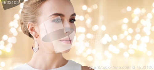 Image of close up of woman in white with pearl earring