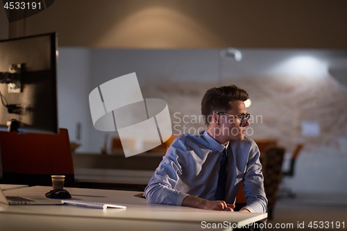 Image of man working on computer in dark office