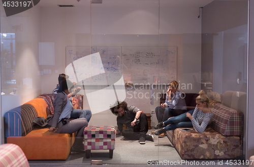 Image of software developers sleeping on sofa in creative startup office