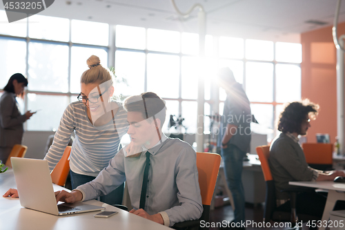 Image of Two Business People Working With laptop in office