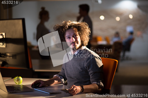 Image of man working on computer in dark office