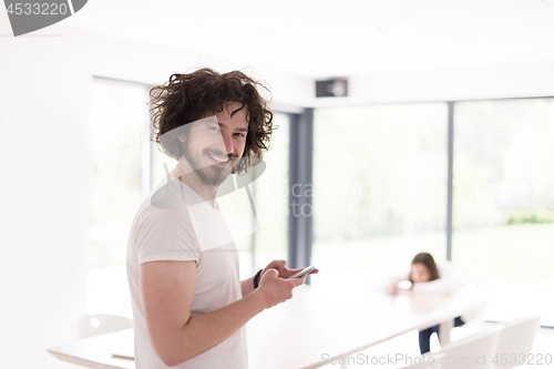 Image of young man using a mobile phone  at home